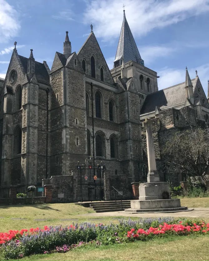 Picture of Rochester Cathedral with grass and red flowers in the forefront
