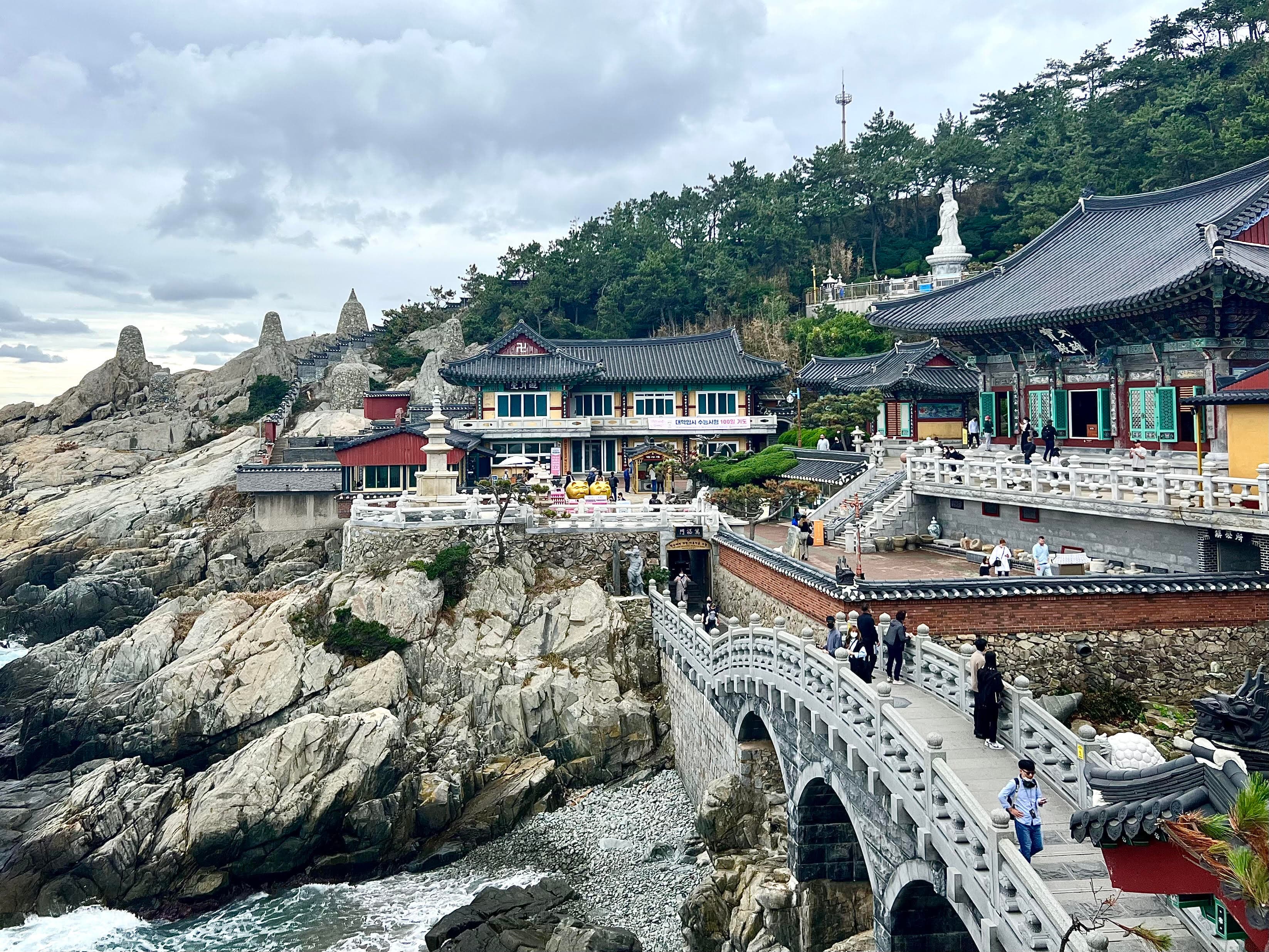 View of historic asian buildings on a rocky seaside cliff.