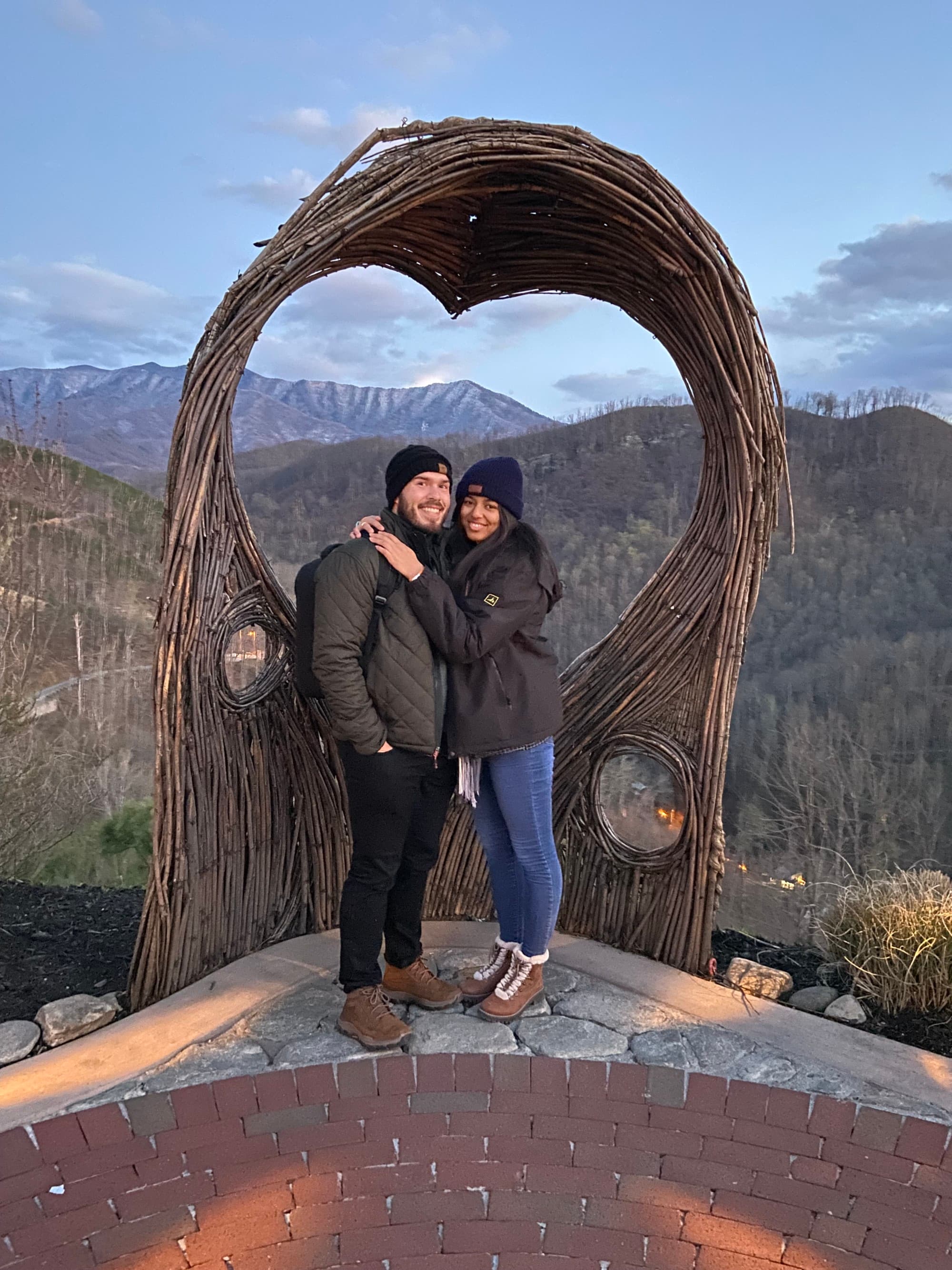 Travel advisor standing with a man with mountains at the back.