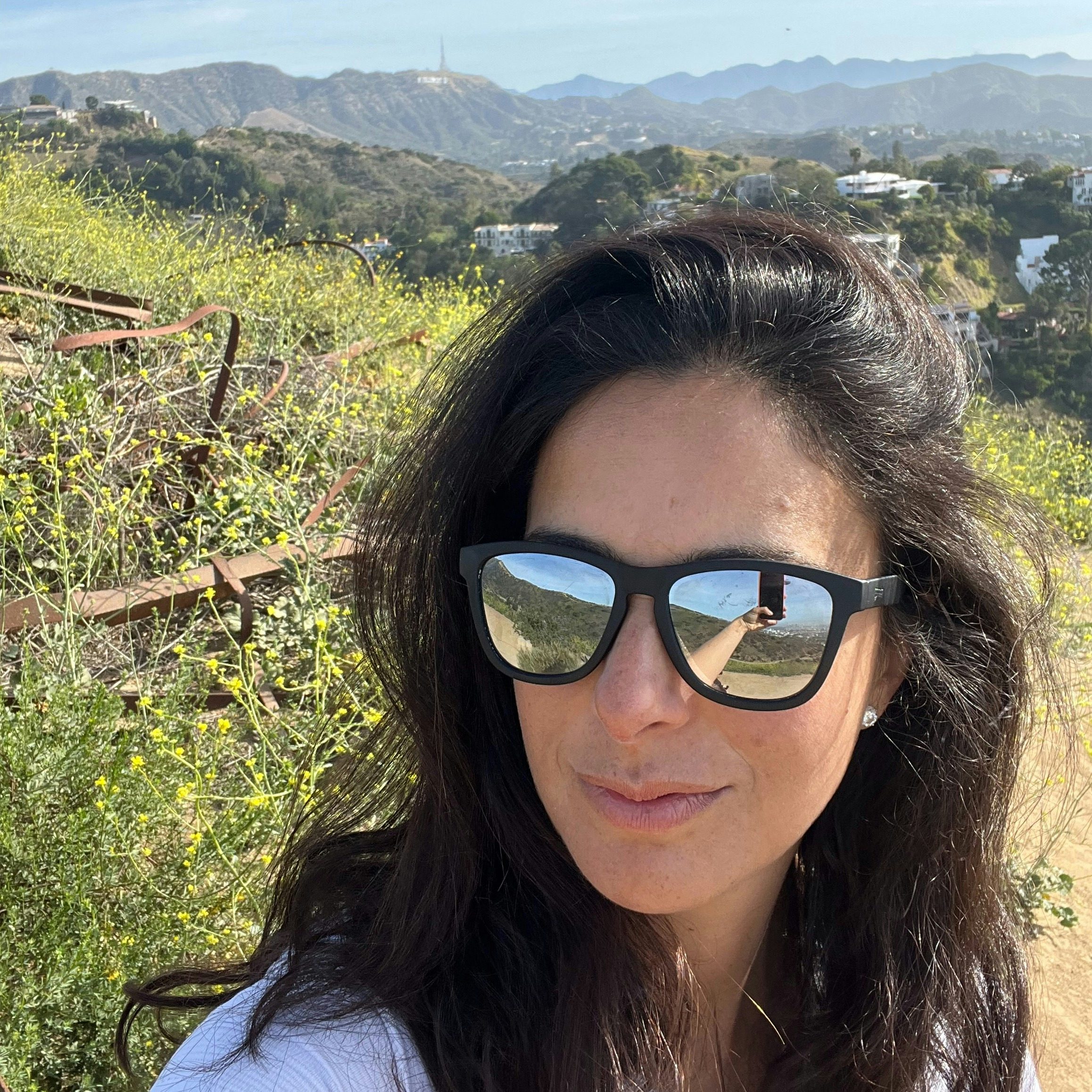 Travel Advisor Clarita Fodor in black sunglasses in front of a green grassy hill.