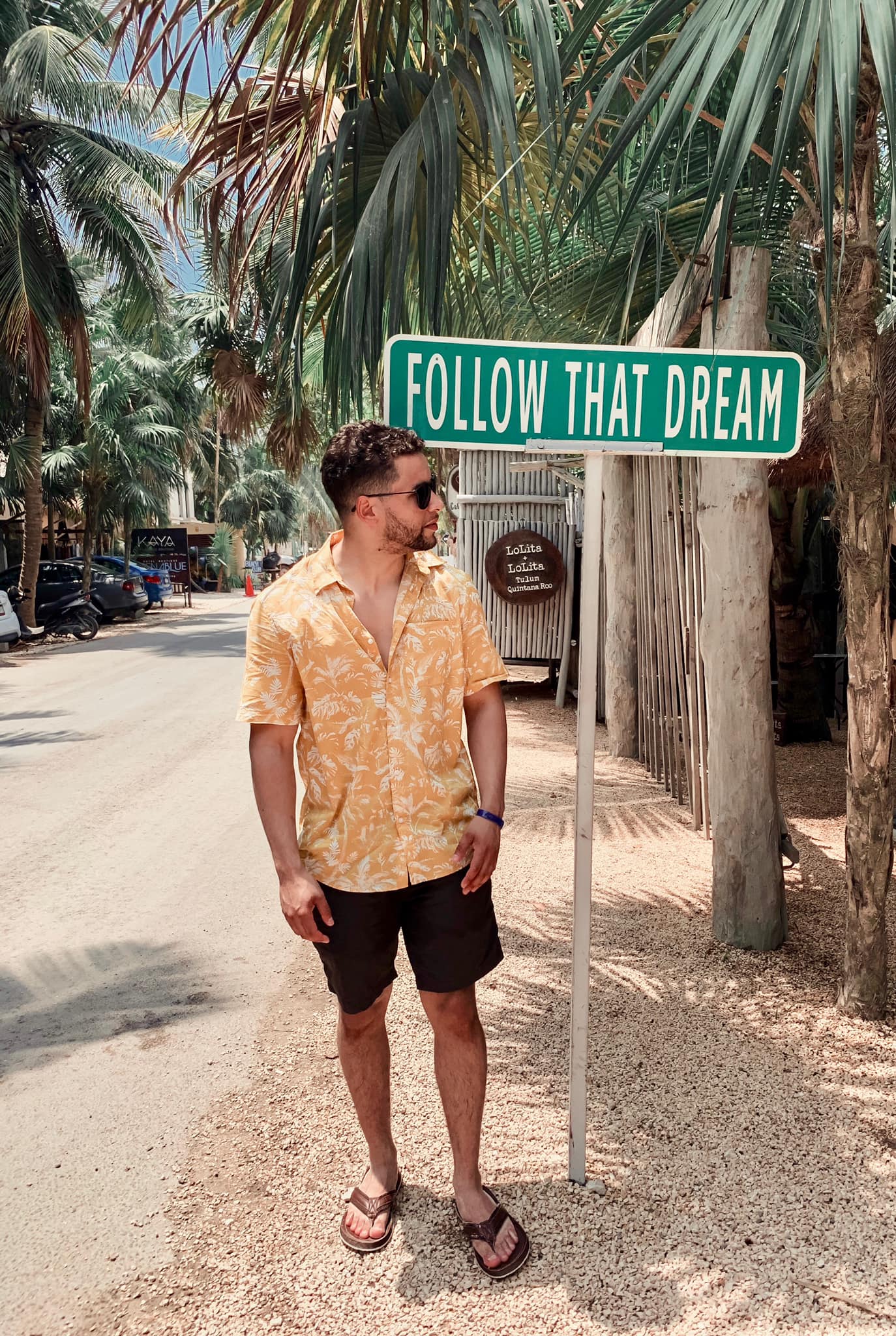 A man standing near a board saying Follow that Dream.