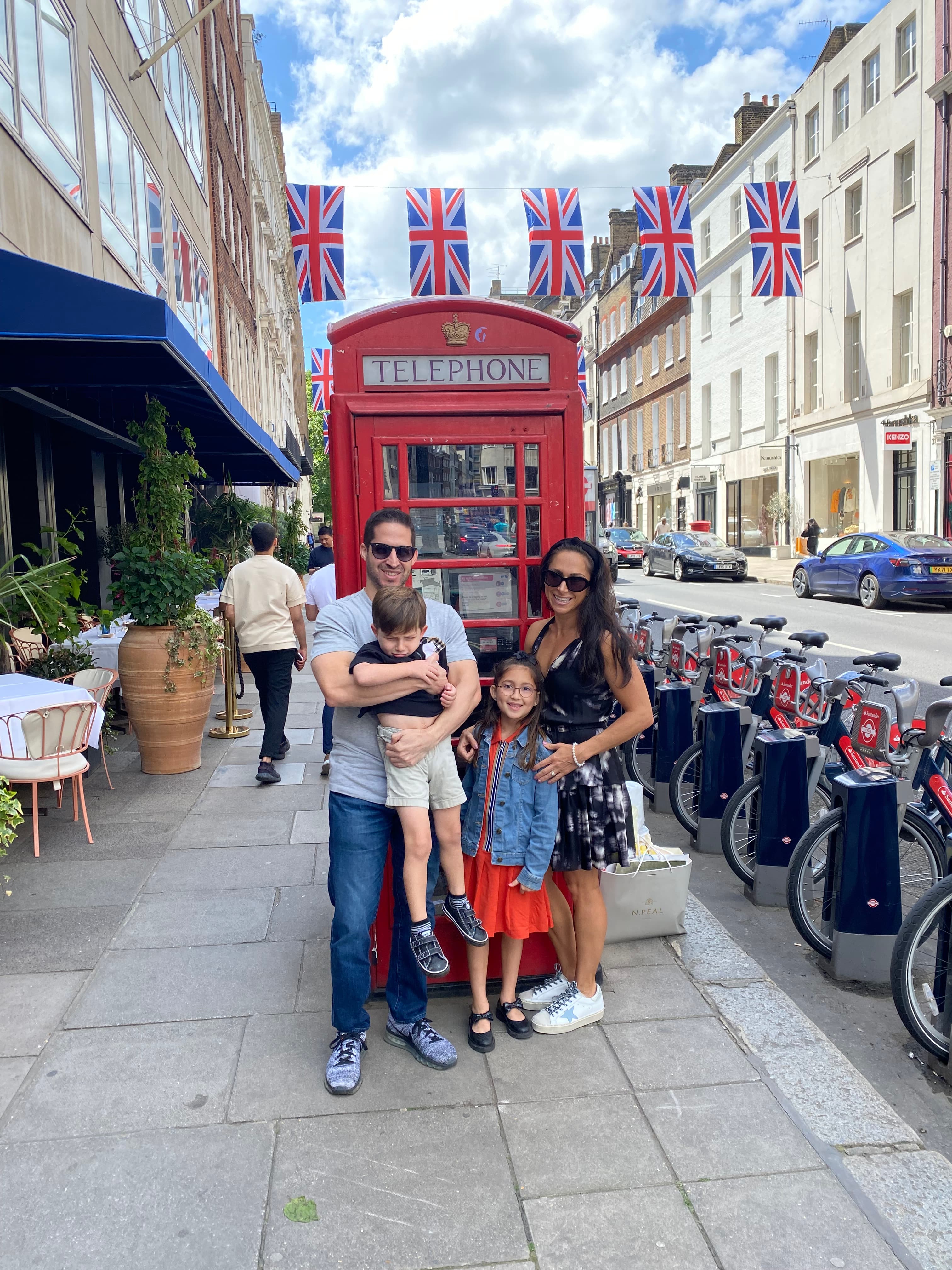 Woman posing with family in front of a red booth