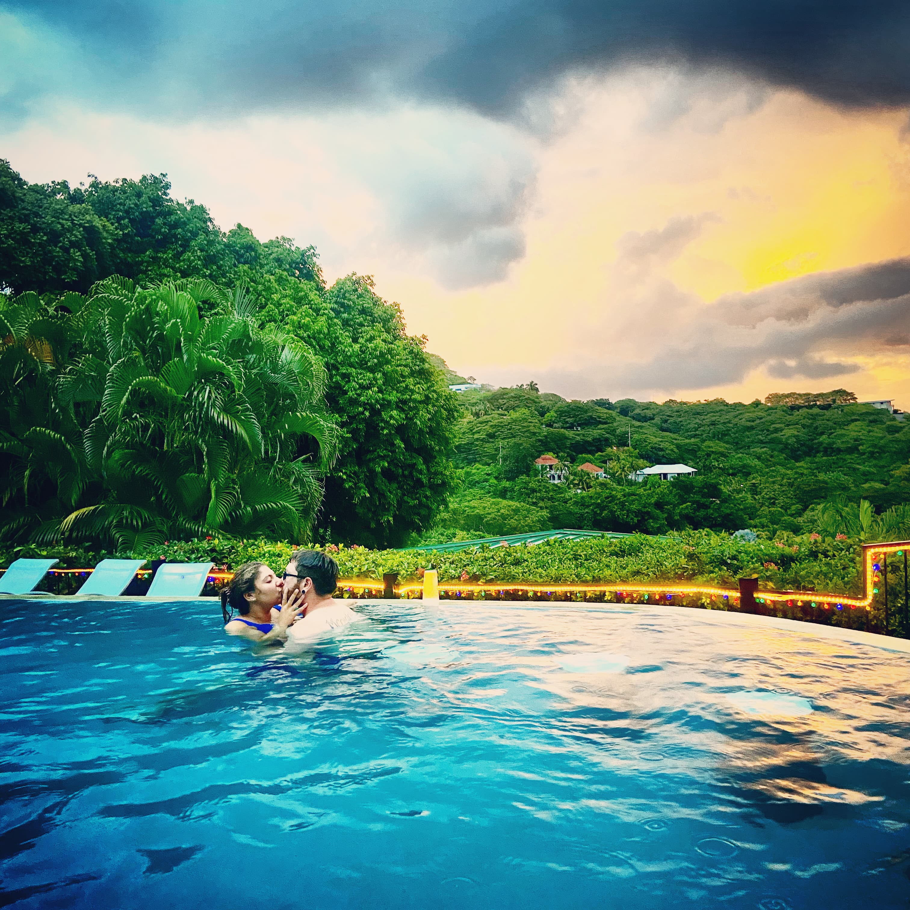 couple in swimming pool sunset