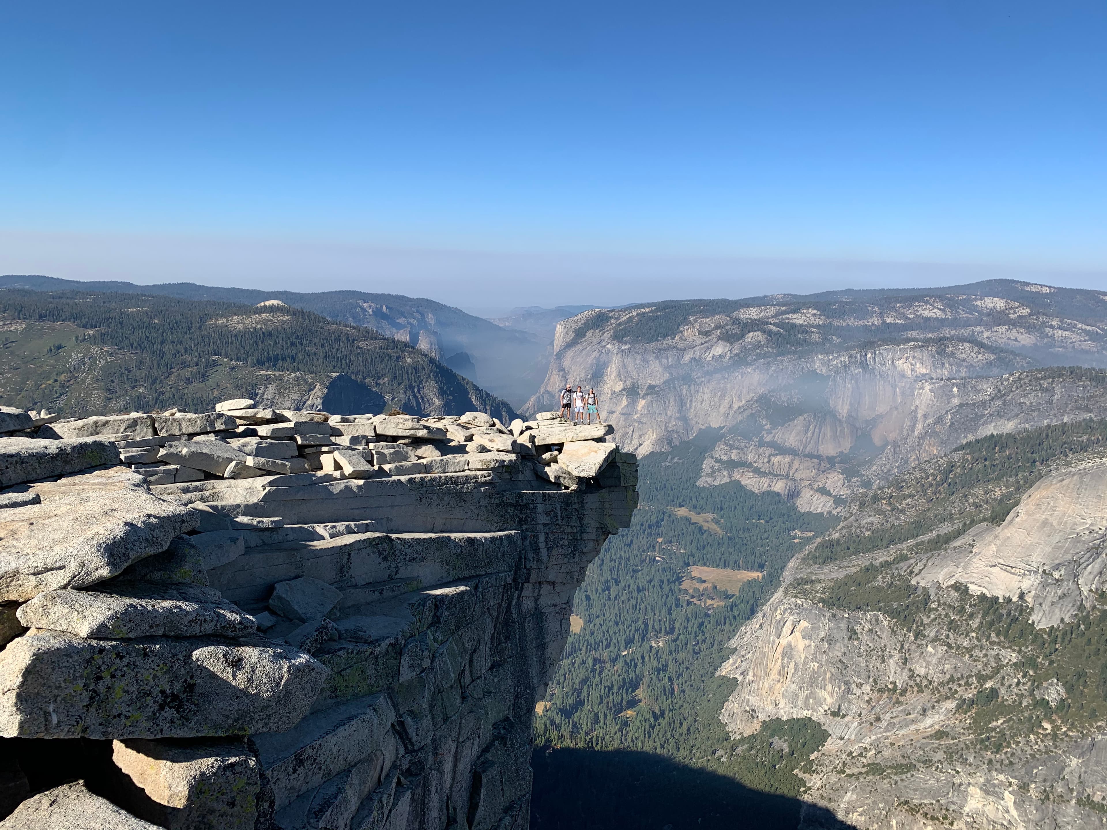 A cliff in Yosemite National Park with mountain views in the background