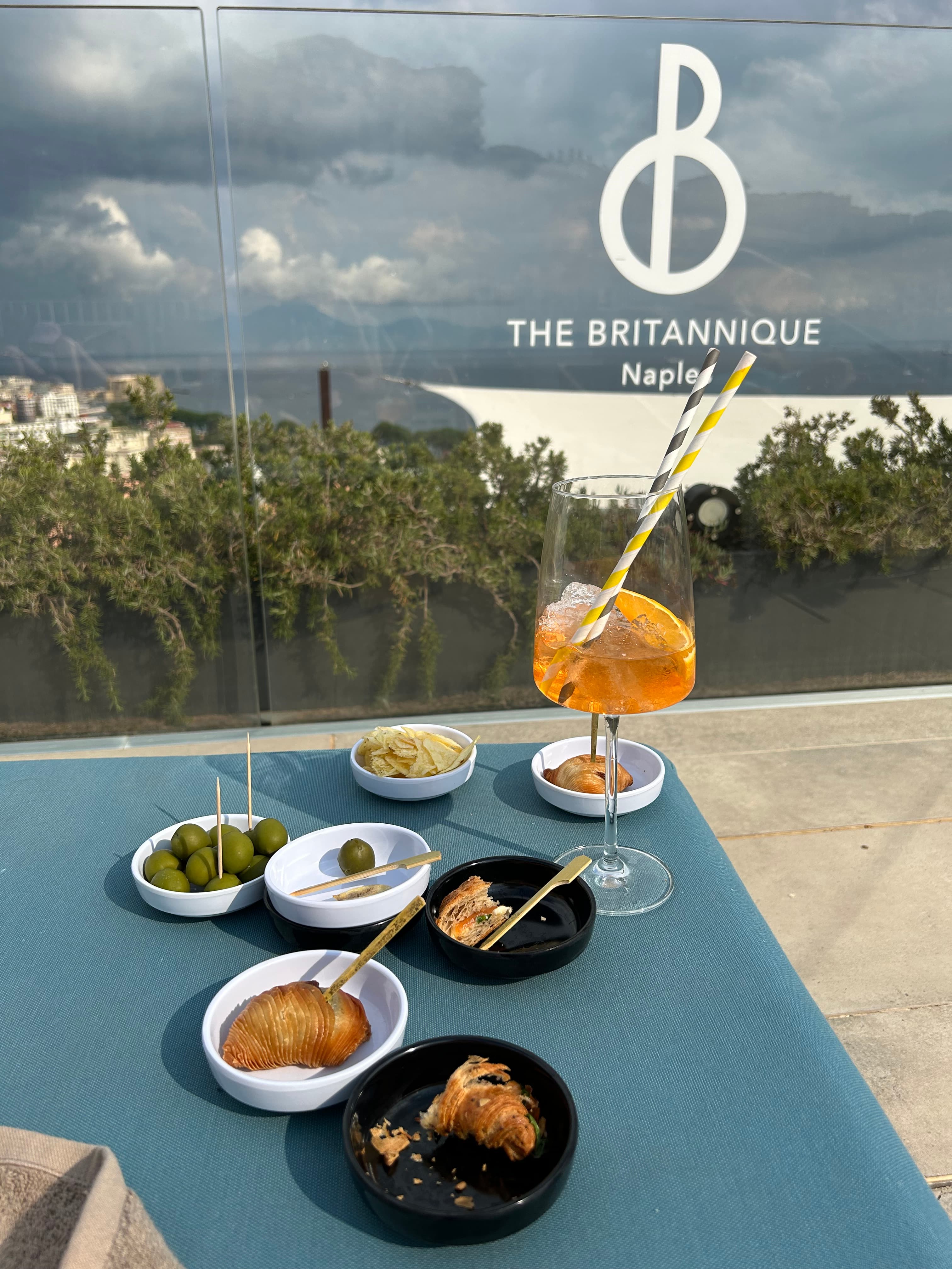 Elegant snacks and cocktail set on an a a blue, outdoor table.