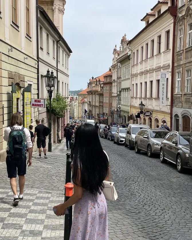 travel advisor becca santos in a purple dress on an old city street