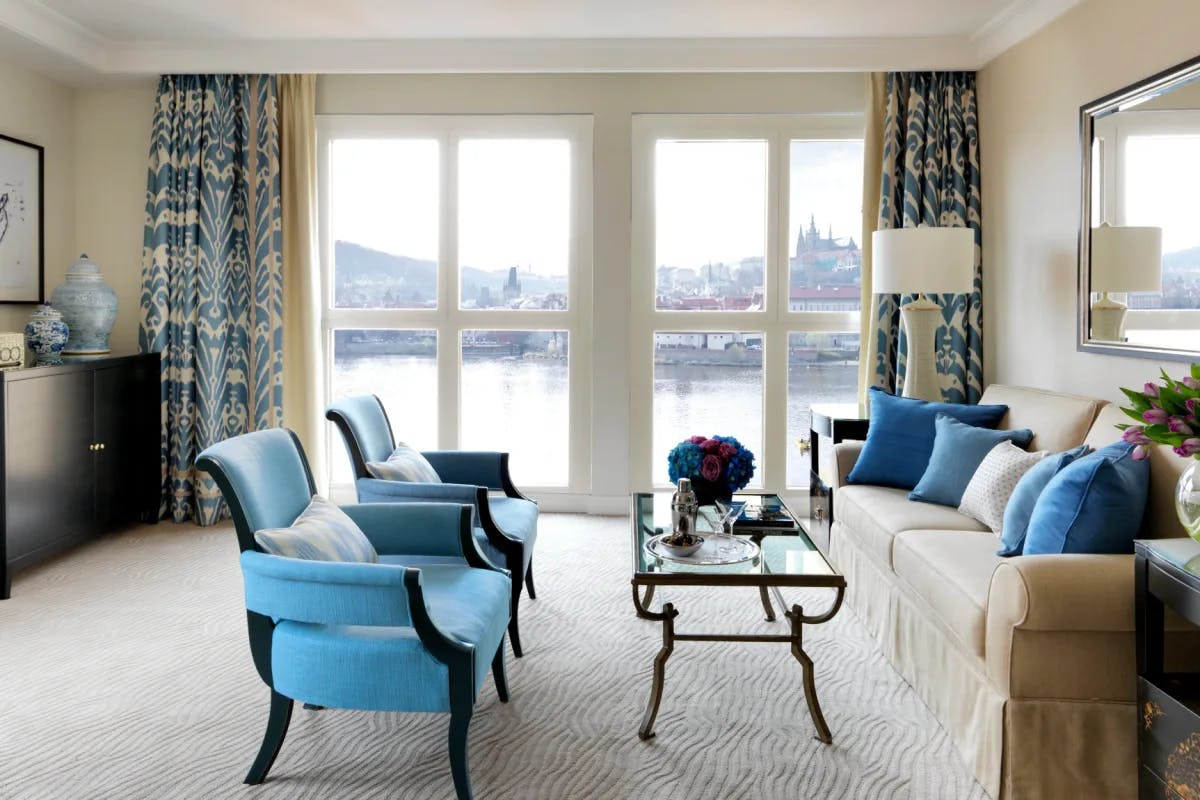 a luxe hotel room with floor-to-ceiling windows overlooking a river