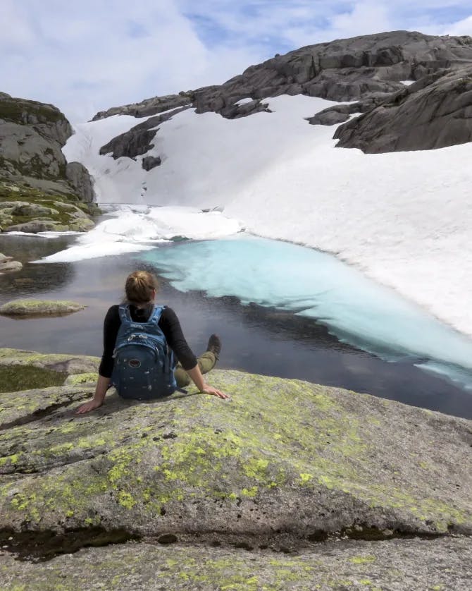 woman sits on rock on a glacier