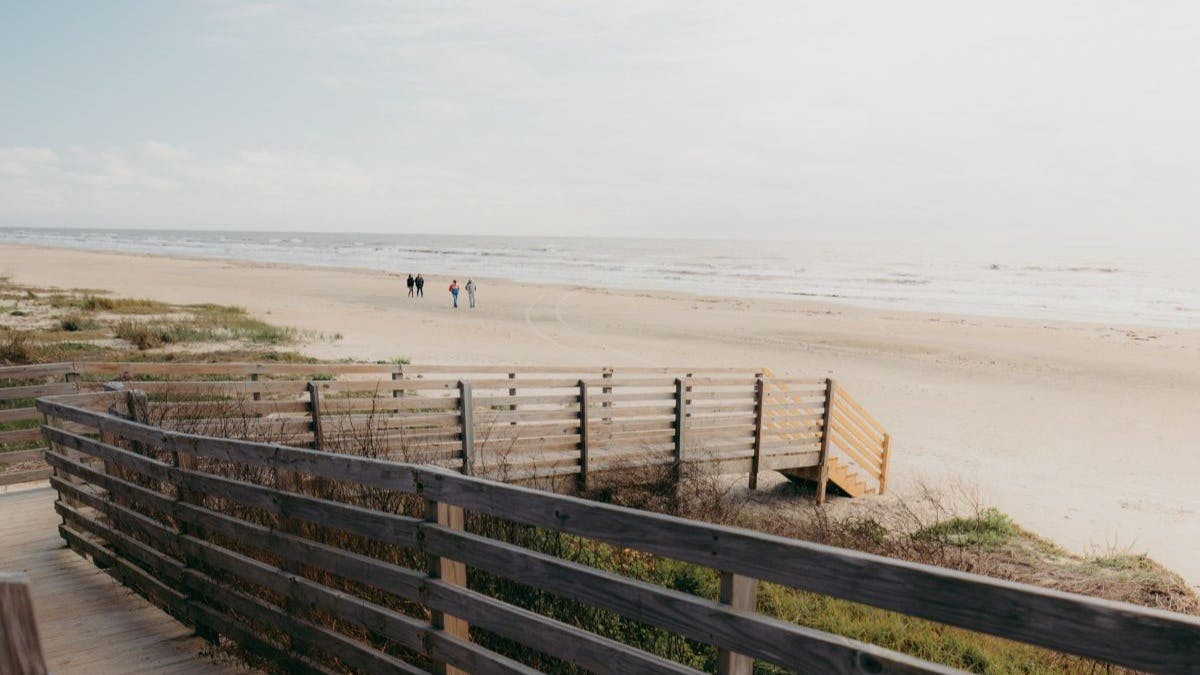 A wooden boardwalk sitting on a beach during daytime