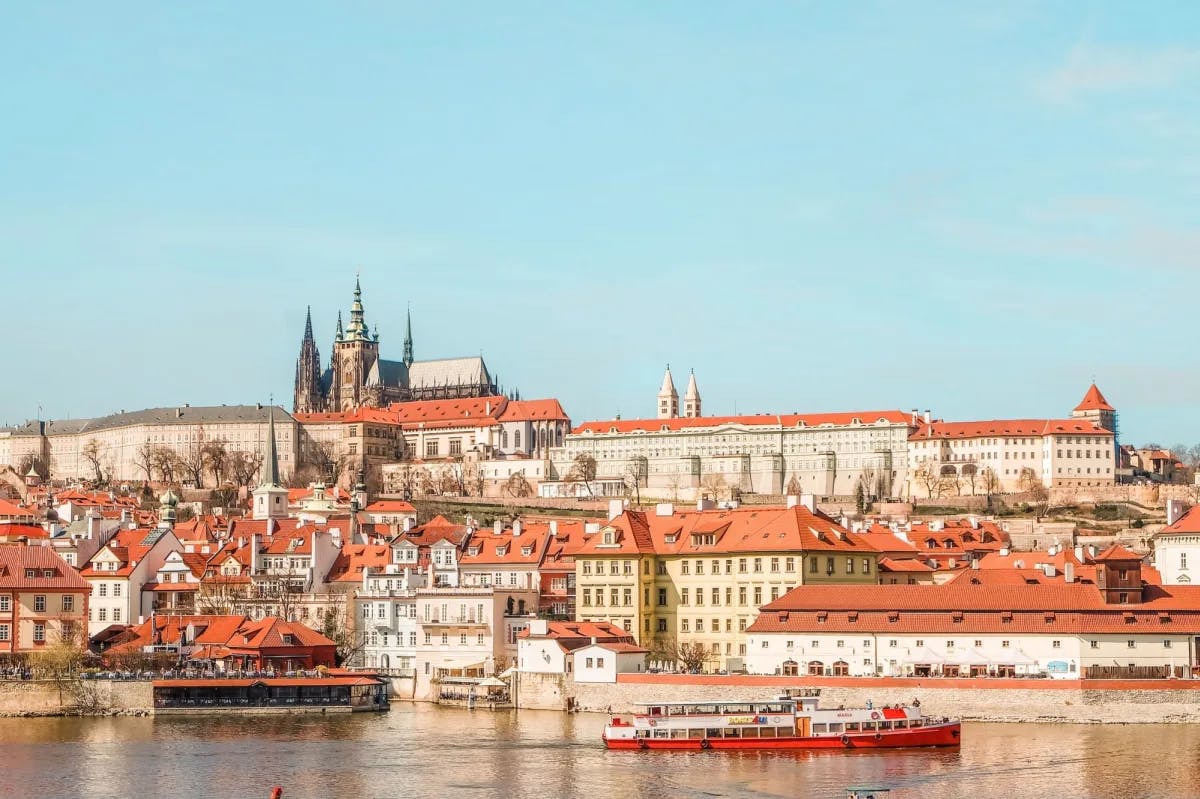 From across the waterfront, the orange-tiled roofs of Prague's historic district are visible