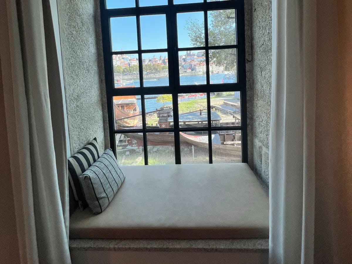 A room at the Rebello Hotel with a window overlooking the water.