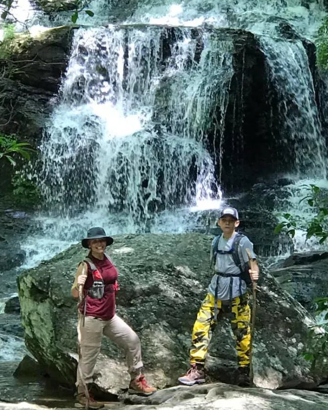 Posing for a picture by the waterfall