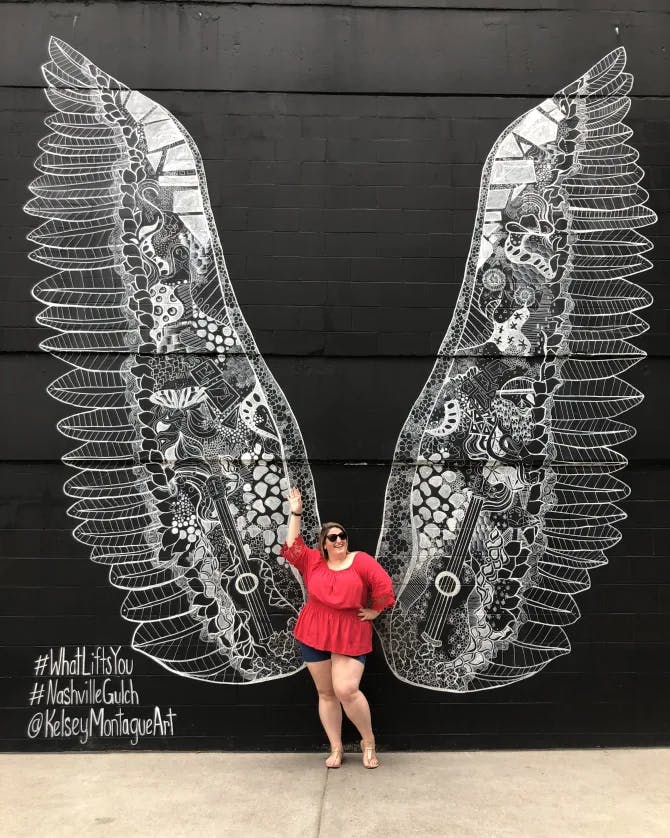 Posing with angel wings graffiti