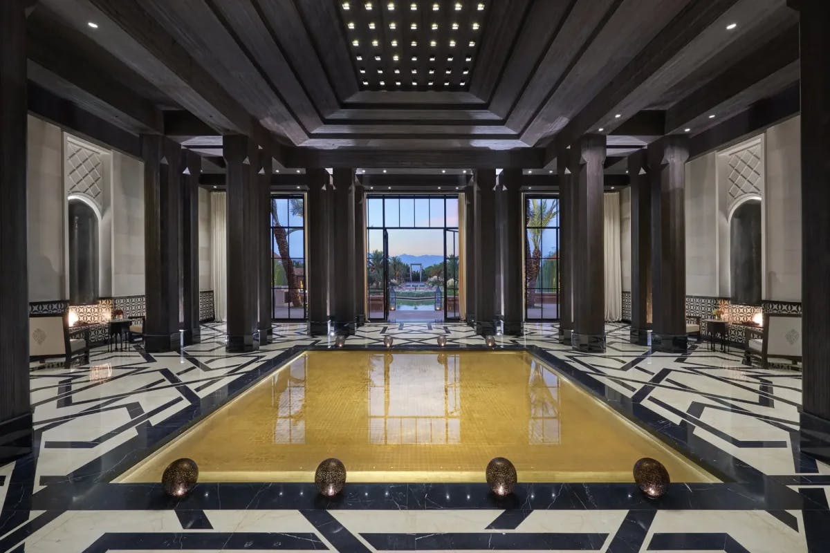 Marble floors, glowing floor orbs, ebony hardwood columns, and gold and white tiles all fill the resort lobby