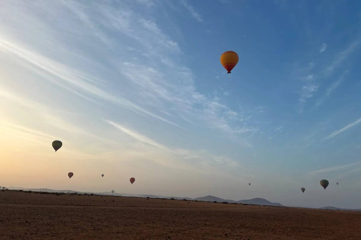 Hot air balloons in the sky over a desert