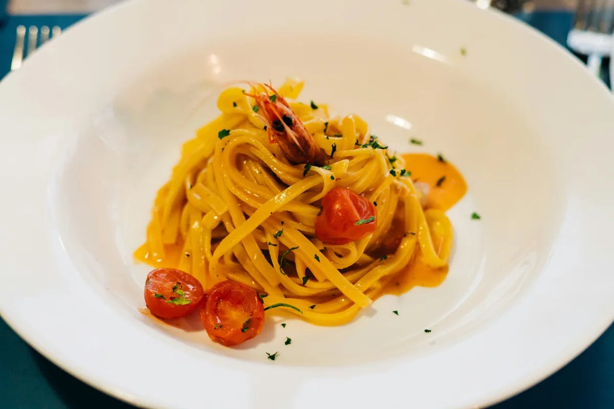 Linguine with tomatoes on a white plate.