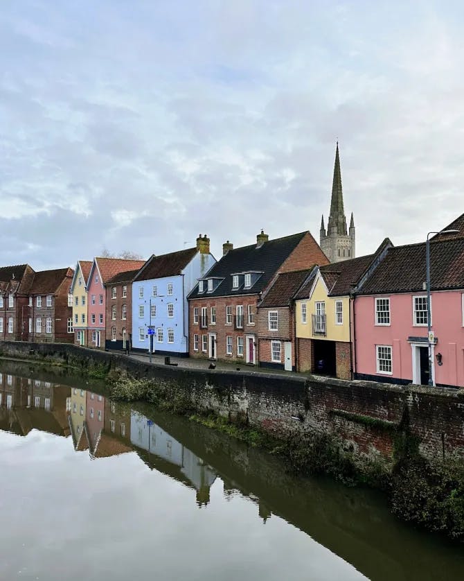 A view of colorful homes aligning a river in England