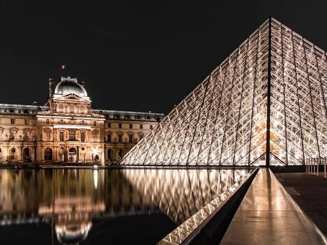 A glass pyramid during nighttime