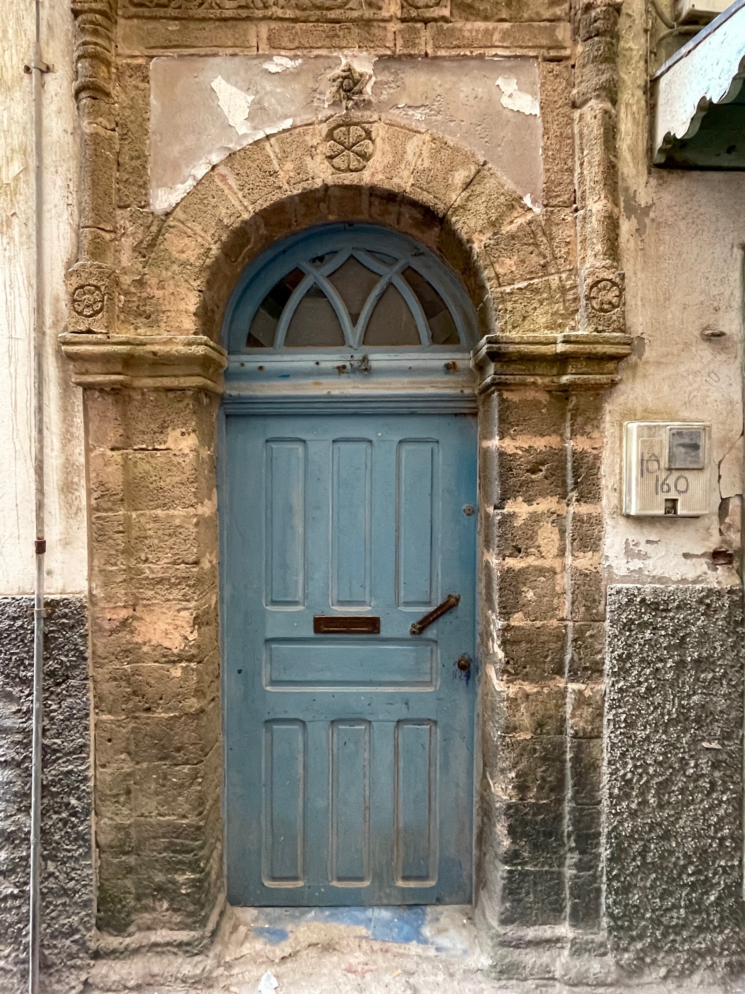 A blue door in a concrete brick wall in Essaouria on the last day of a Morocco 7 day itinerary.