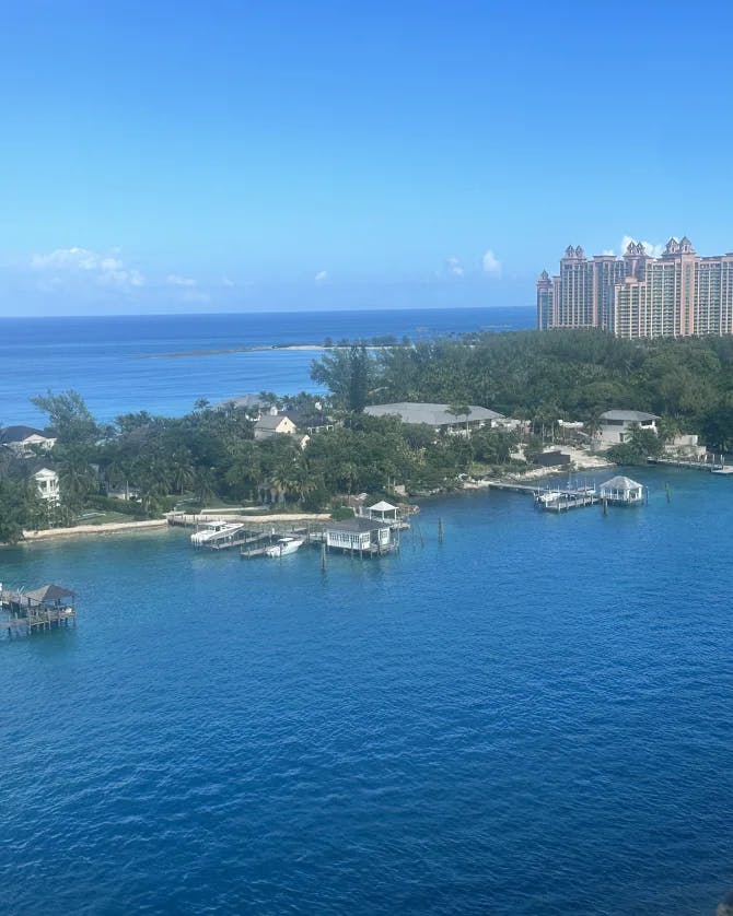 An aerial view of blue sea water surrounding a harbor with a resort building to the right