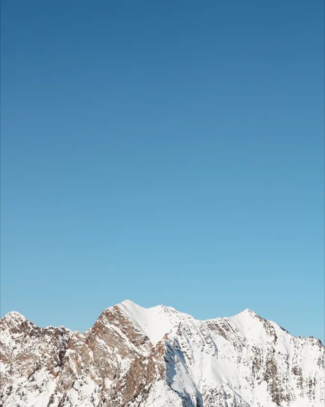 Picture of a snow covered mountain top and clear blue sky