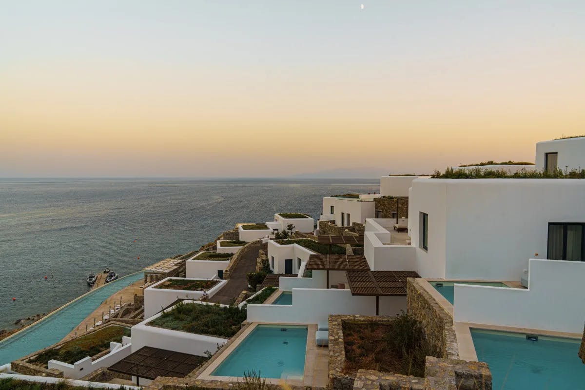 white square buildings with private plunge pools overlook the sea