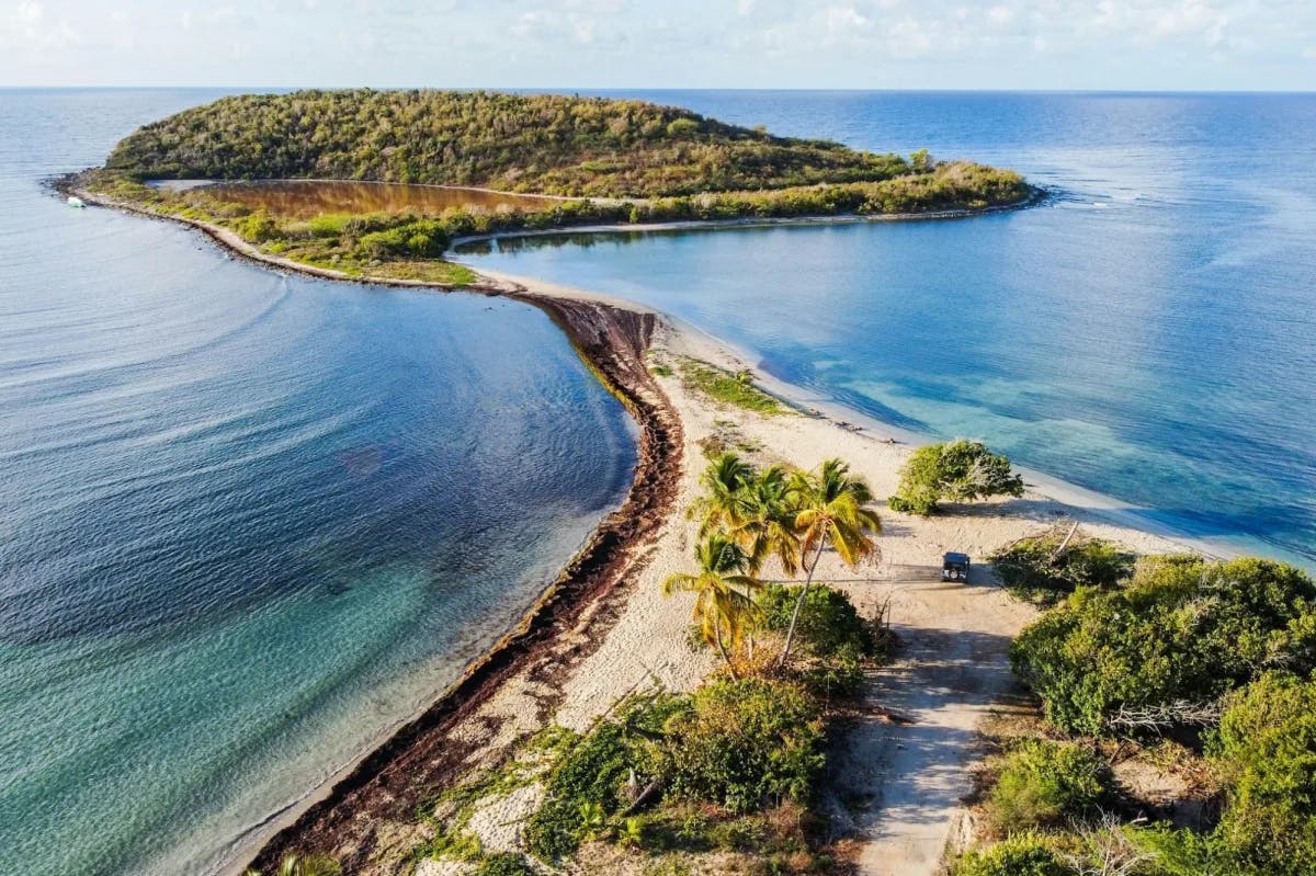 A tiny peninsula in Vieques, Puerto Rico: lush vegetation and white sands are surrounded by sapphire-blue waters on either side
