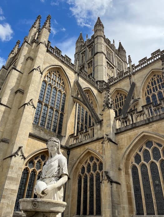 Grand stone cathedral with stone statue of a woman.