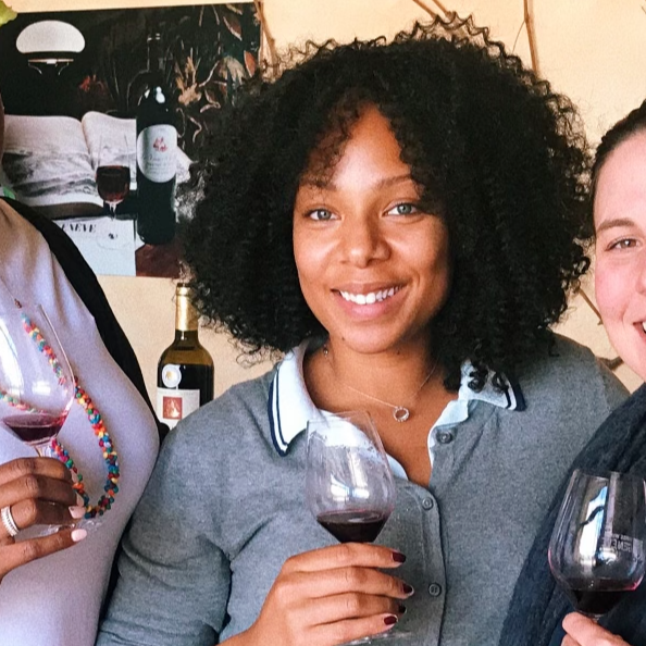 Travel Advisor Aazia Mickens-Dessaso in a gray shirt holding a red wine glass.