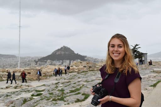 Girl in front of monument with camera.