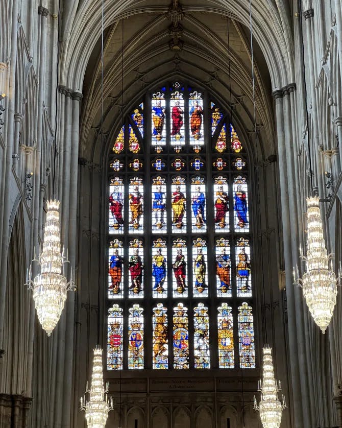 Inside view of Westminster Abbeys stained glass window and chandeliers