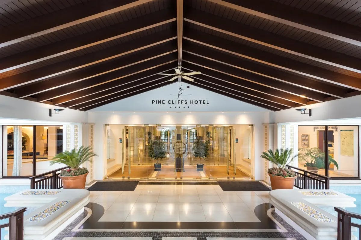 Marble floors, tile fountains, floor-to-ceiling glass doors and windows and fern plants line the entrance to Pine Cliffs Hotel, a Luxury Collection Resort, Algarve
