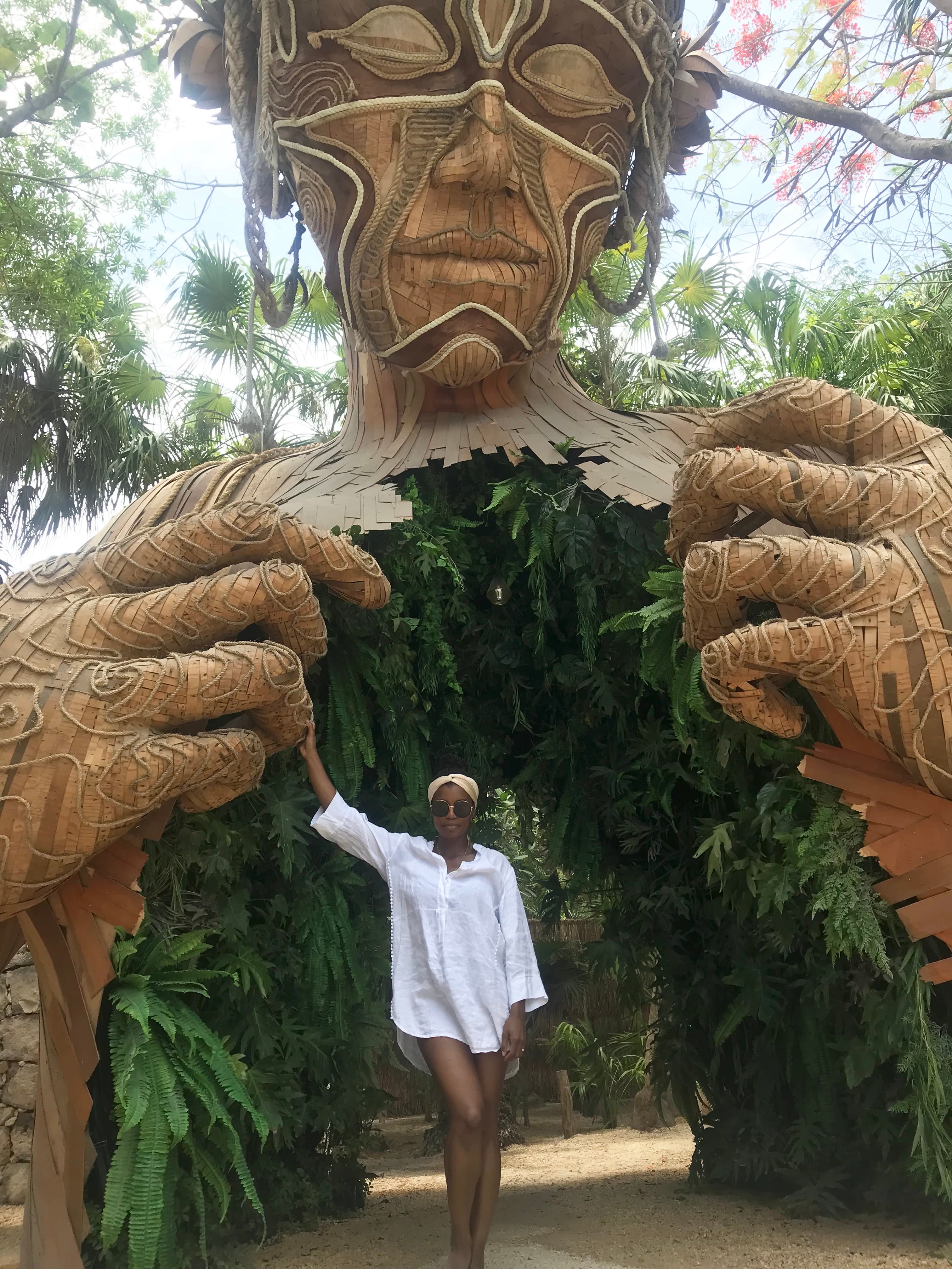 Travel advisor standing in front of a Sculpture of a woman an entrance