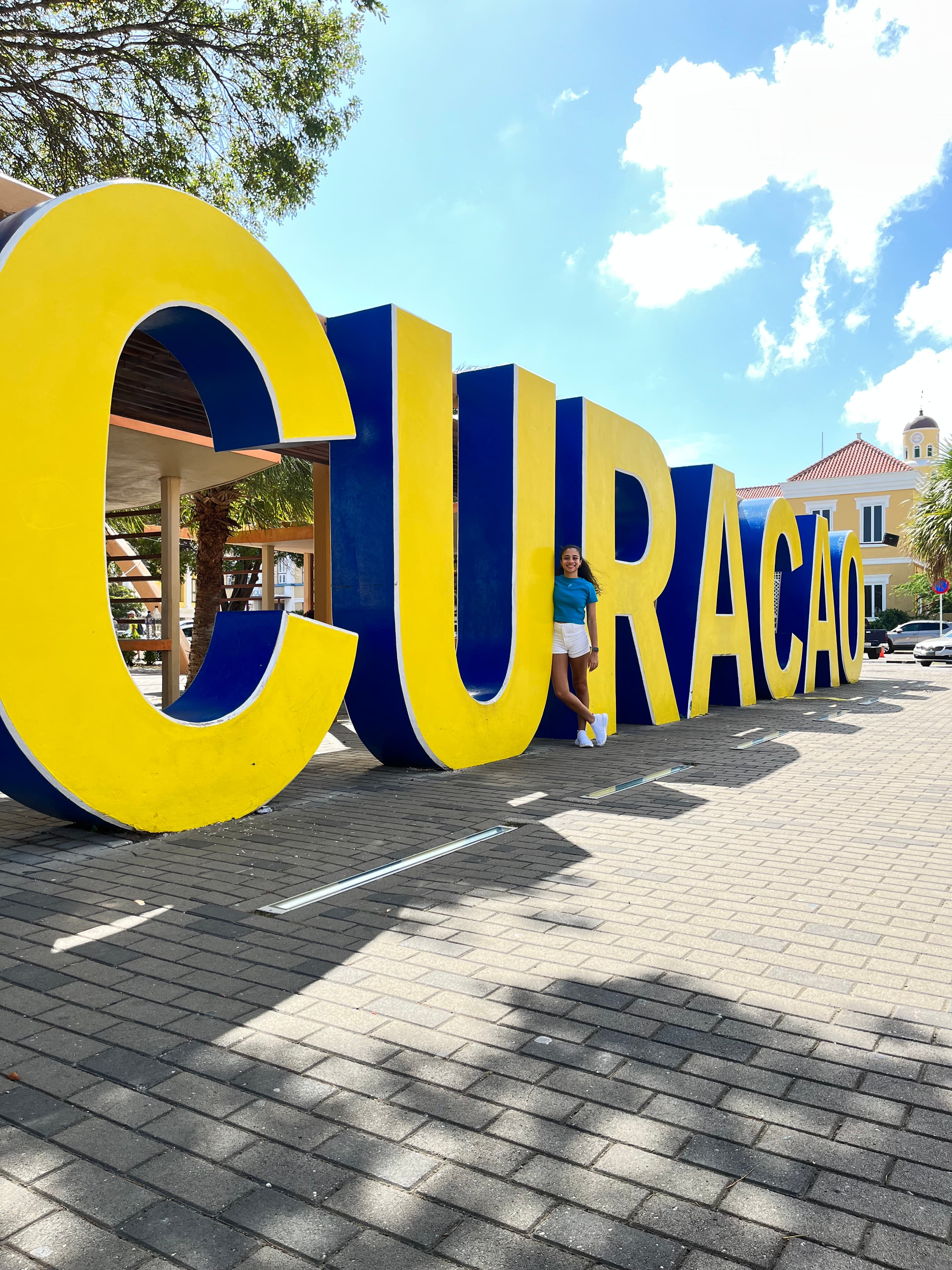 Aoloni between the life size letters of the Curacao sign.