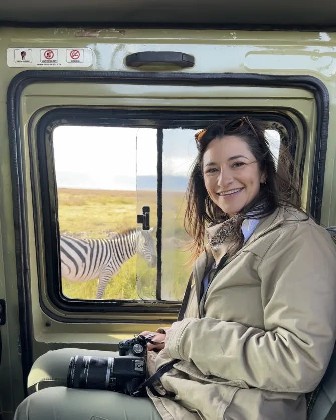 Picture of Shelby inside of a truck on a safari with a zebra in view