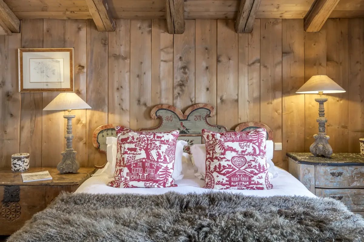 a cozy cabin bed with a furry blanket and two red-and-white pillows