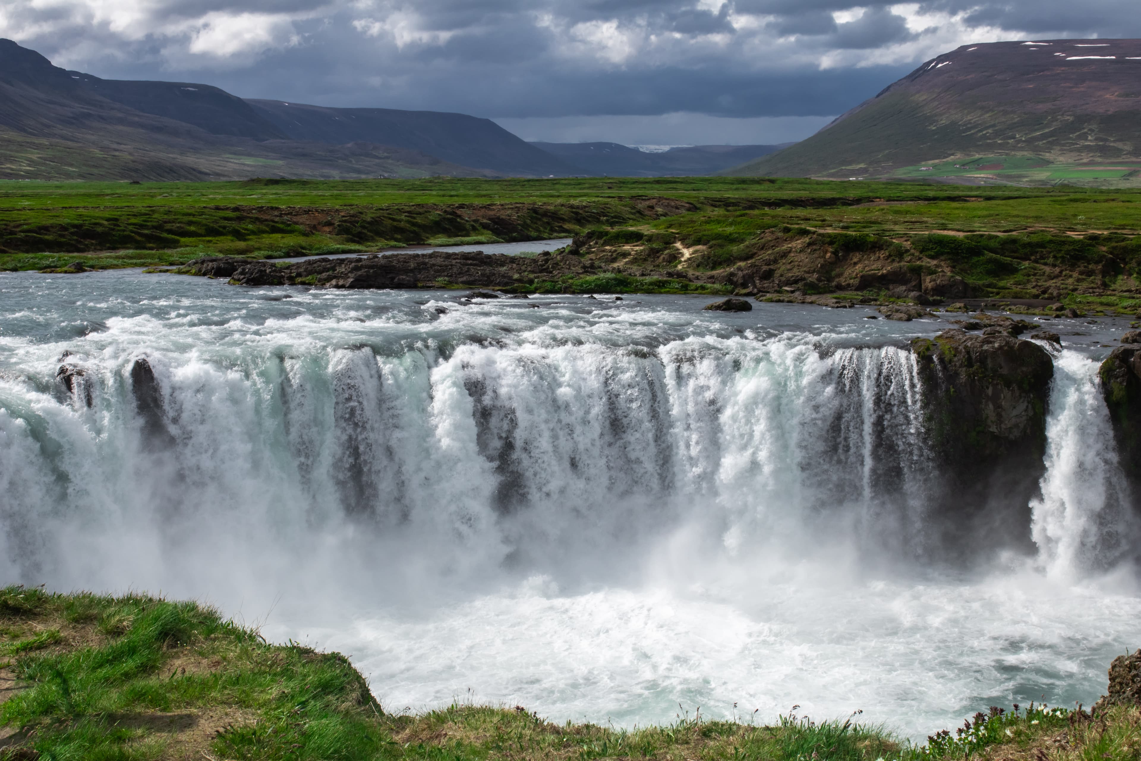 A stunning view of Goðafoss Waterfall on a cloudy day.
