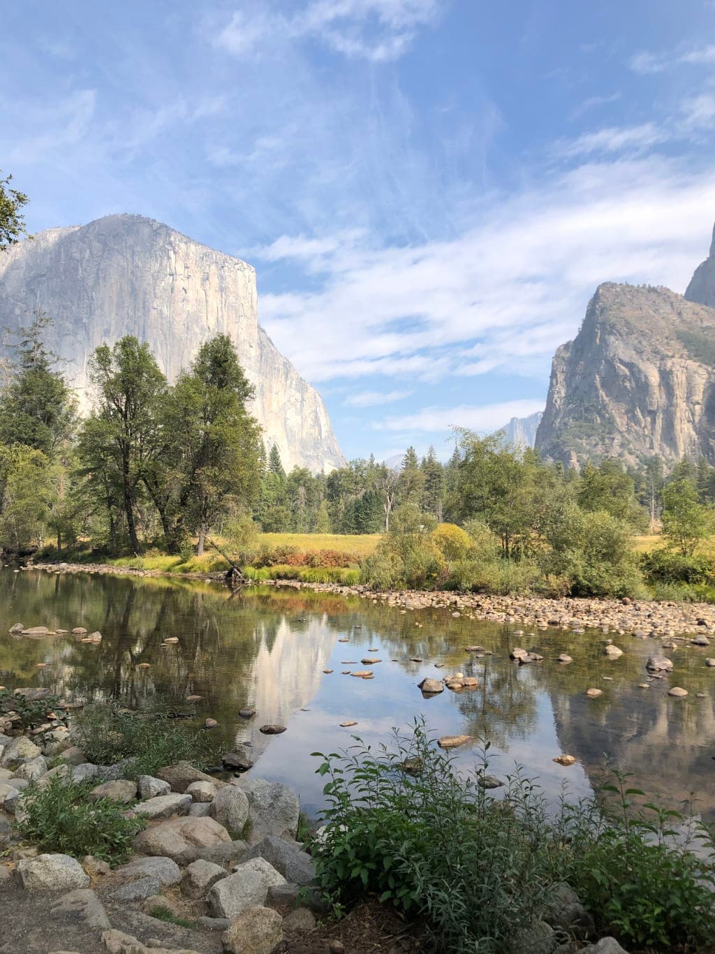 A picture of mountains, trees and a reflective pond.