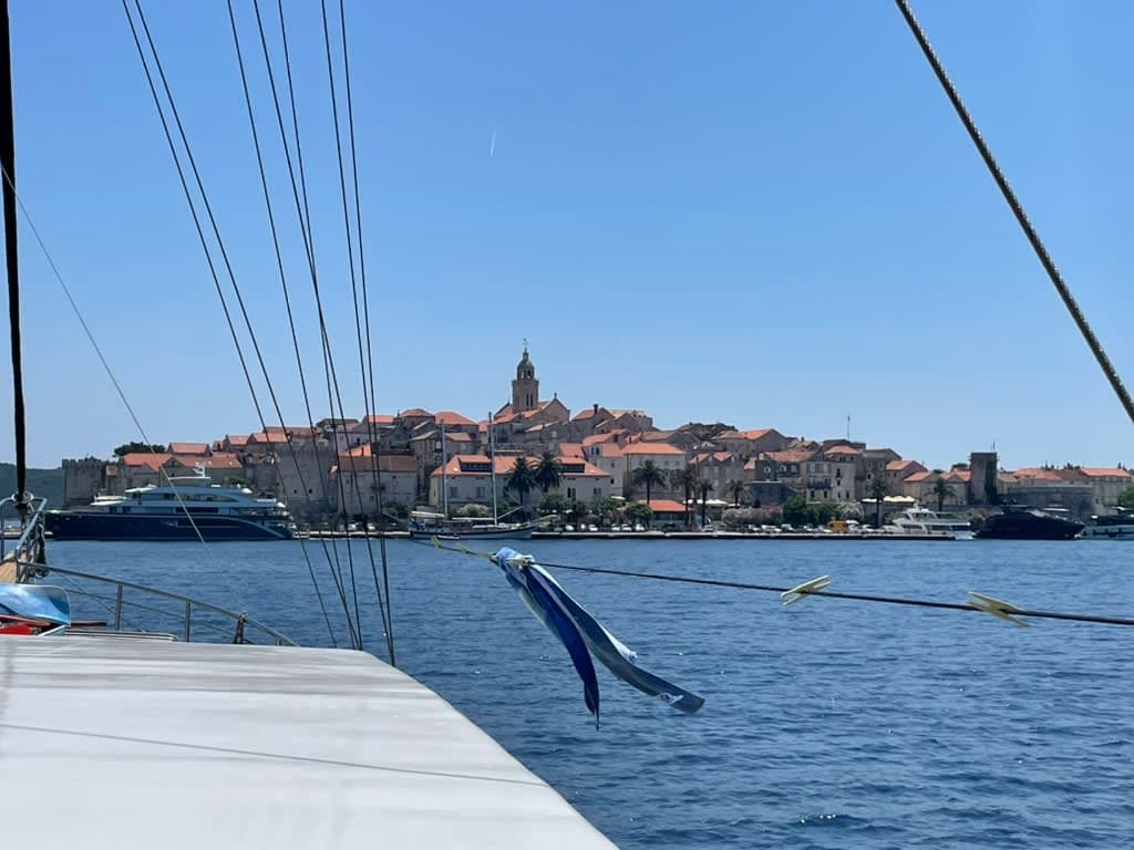 A red-roofed city on a hill seen from a boat deck