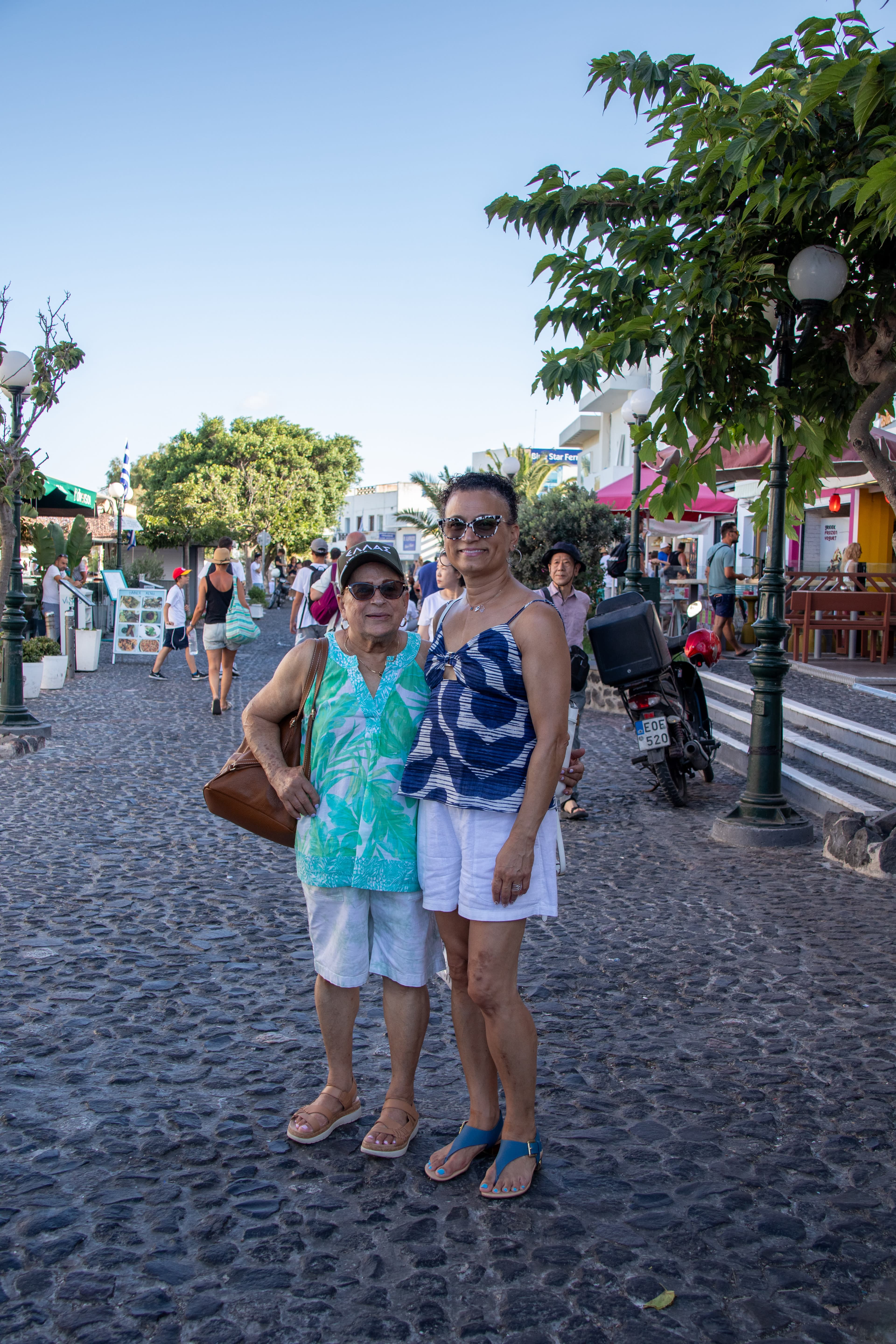 Adrianna and a woman standing in a cobblestone street next to trees