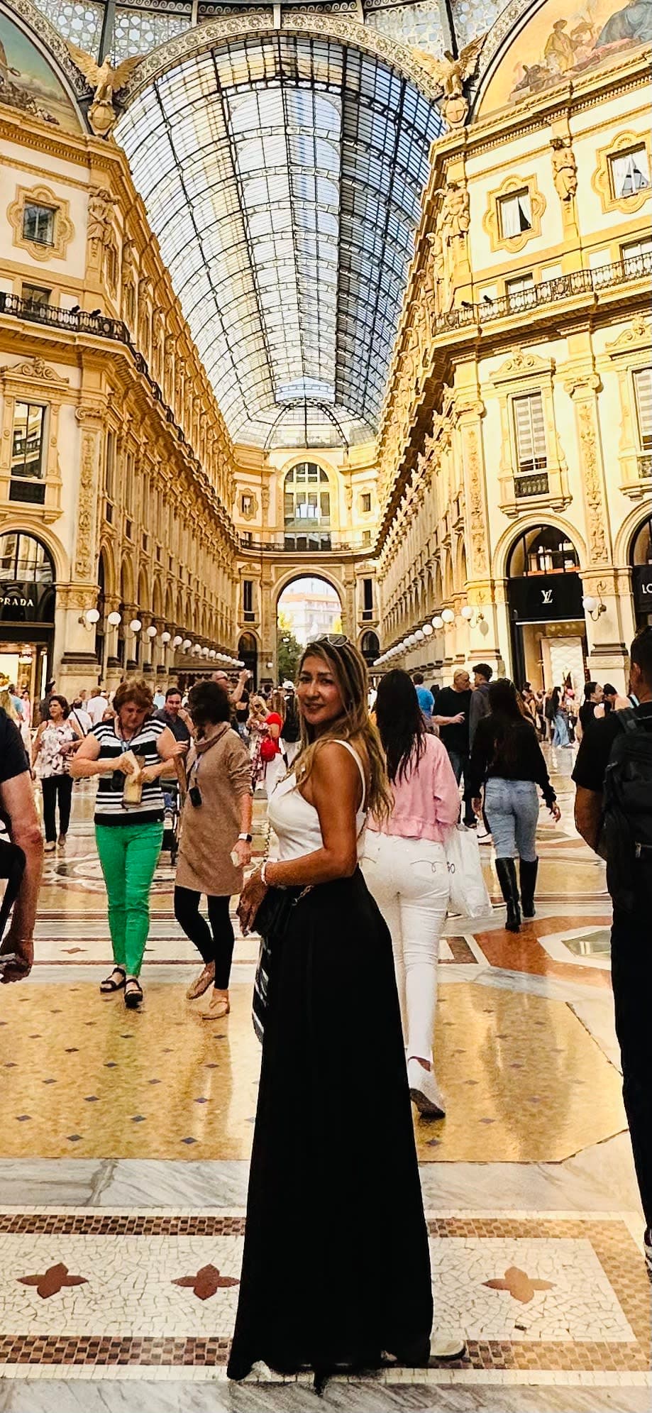 Wendy in a white top and black skirt posing for a photo in Galleria Vittorio Emanuele II