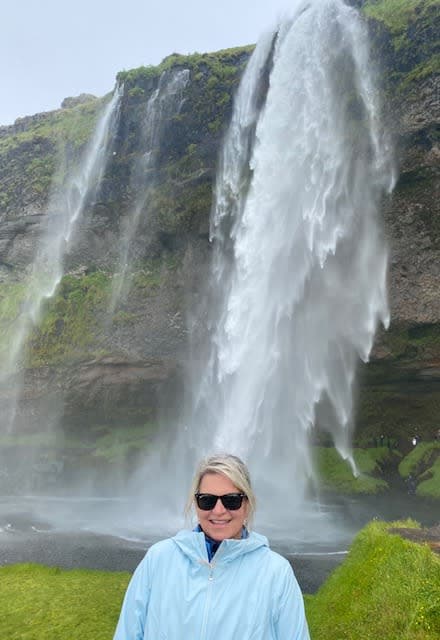 Posing for a photo in front of a waterfall