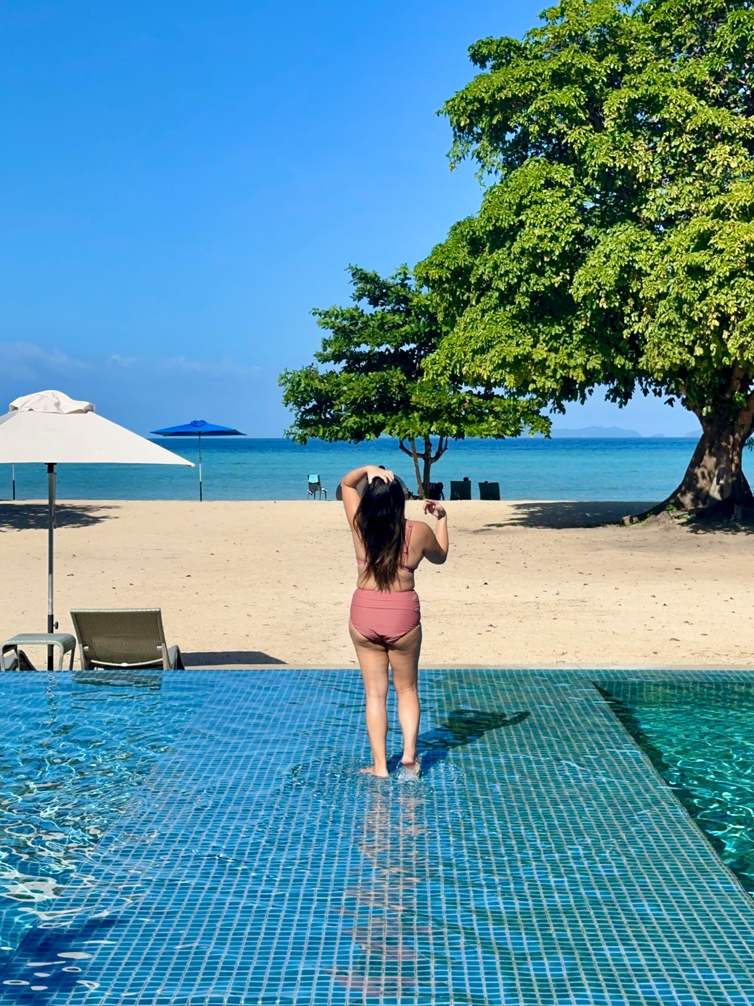 Standing in the pool by the beach