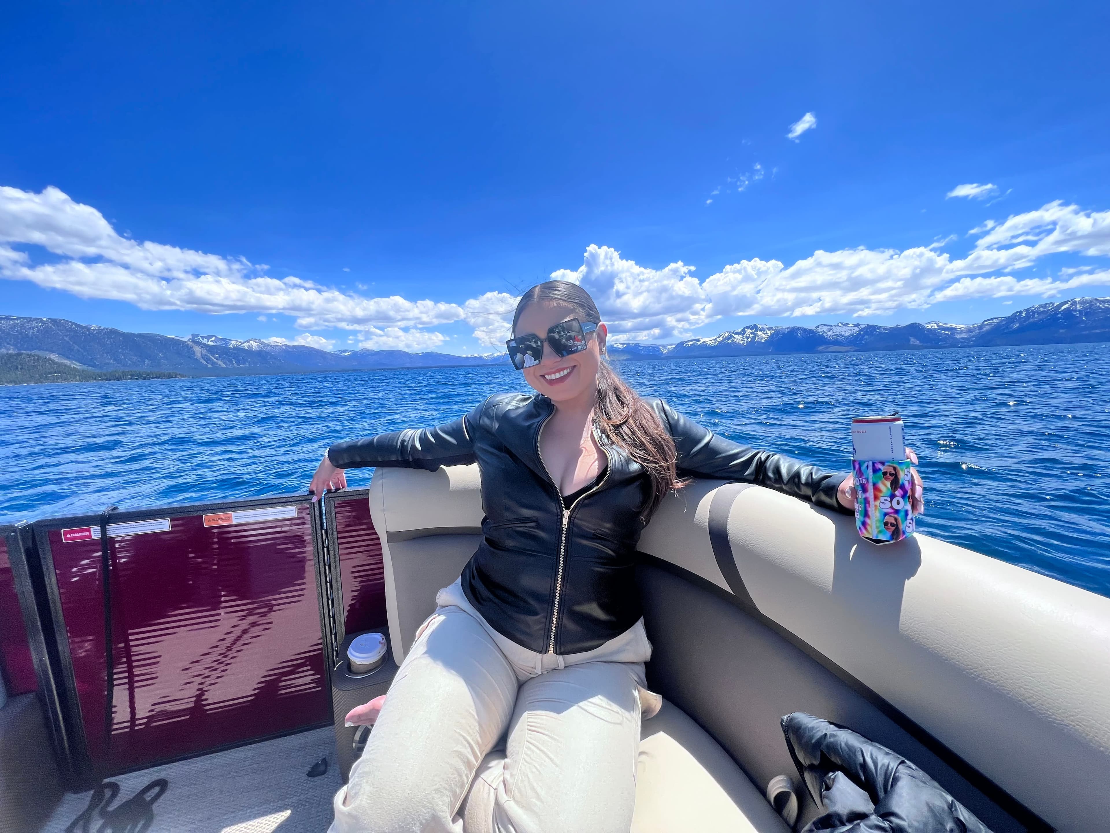 Travel advisor Yiselle Alvarenga sitting on a boat with a drink in her hand with a view of the ocean