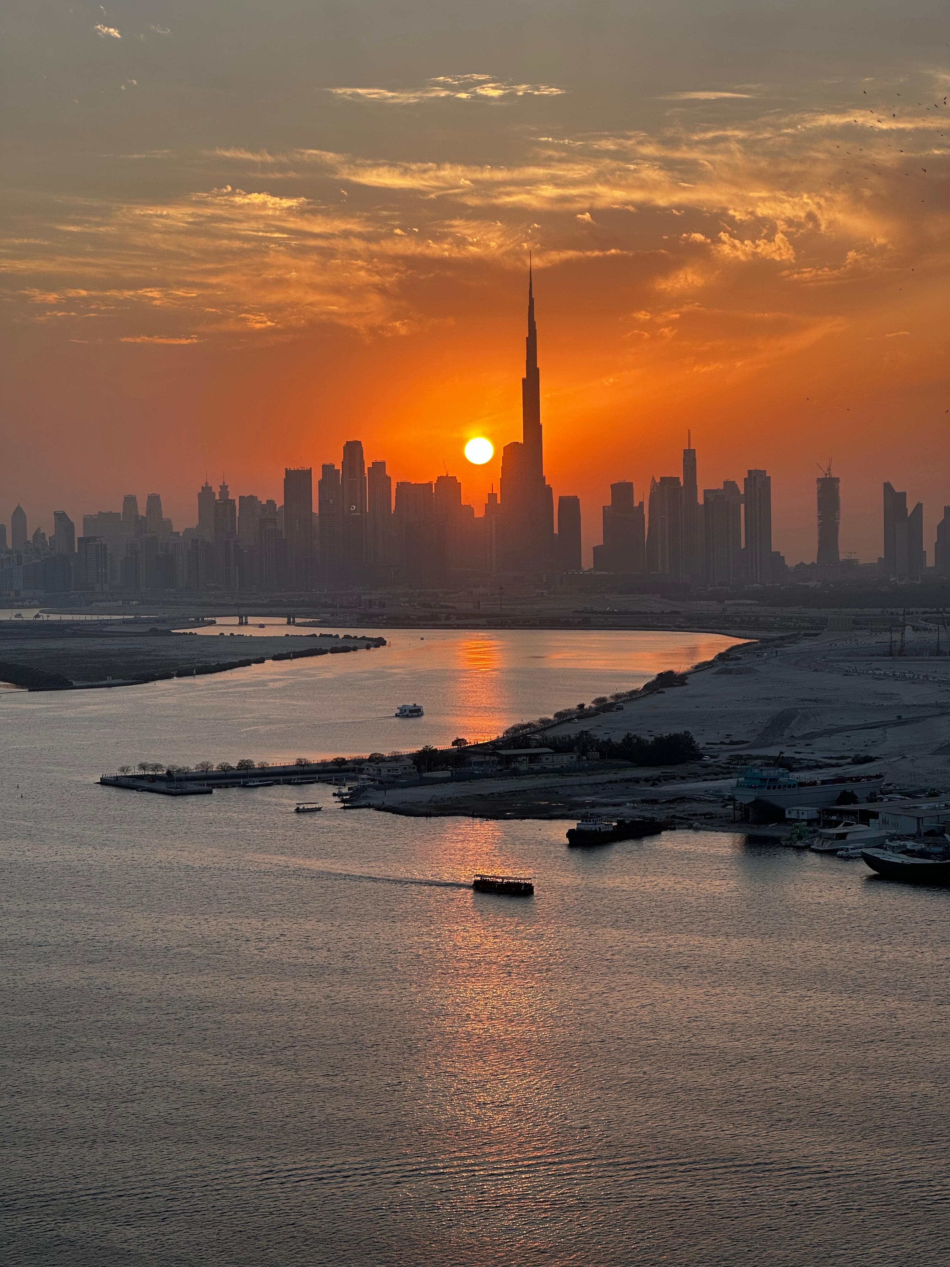 Beautiful view of deep orange sunset over a coastal city with skyscrapers