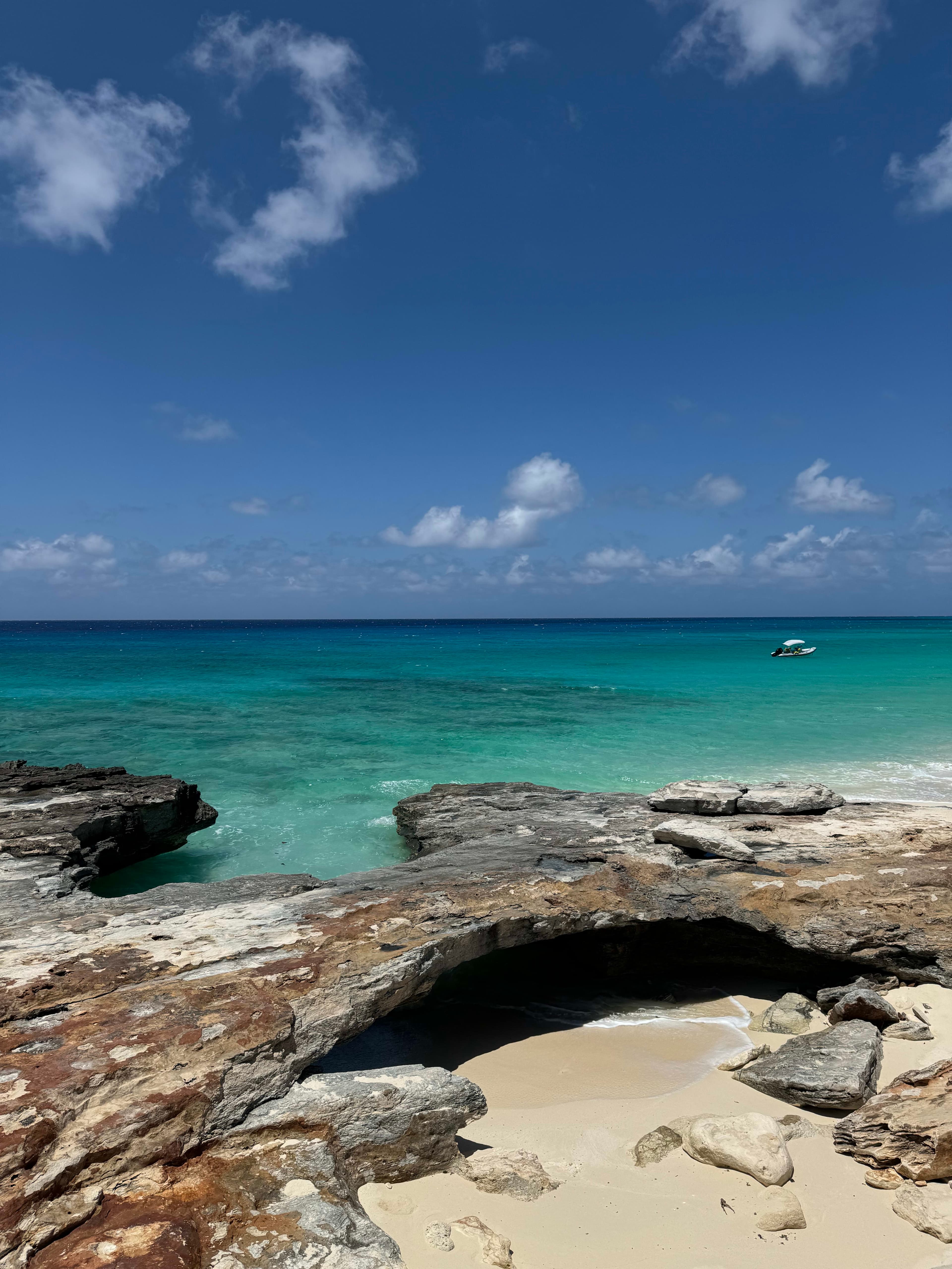 Beautiful view of the beach with large rocks by the shore and different shades of turquoise water