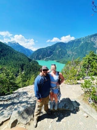 Posing for a couple photo with a beautiful view of the lake in the background