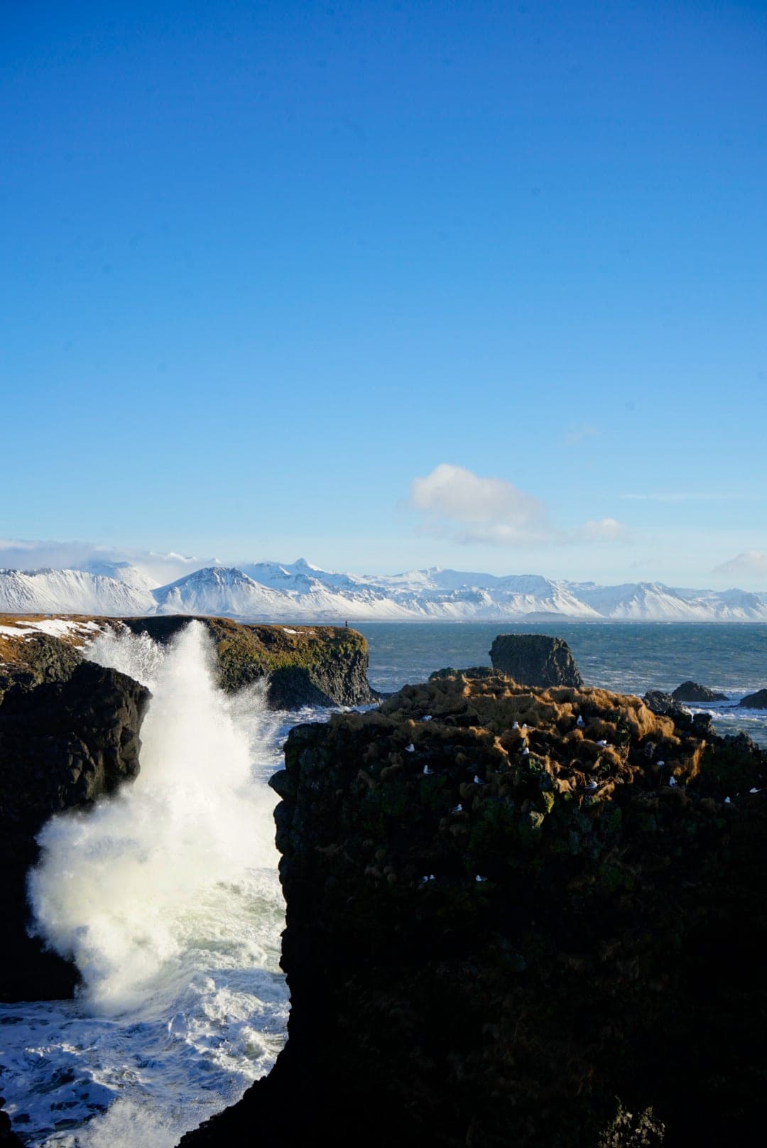 Beautiful view of the waterfall and snow capped mountains in the distance