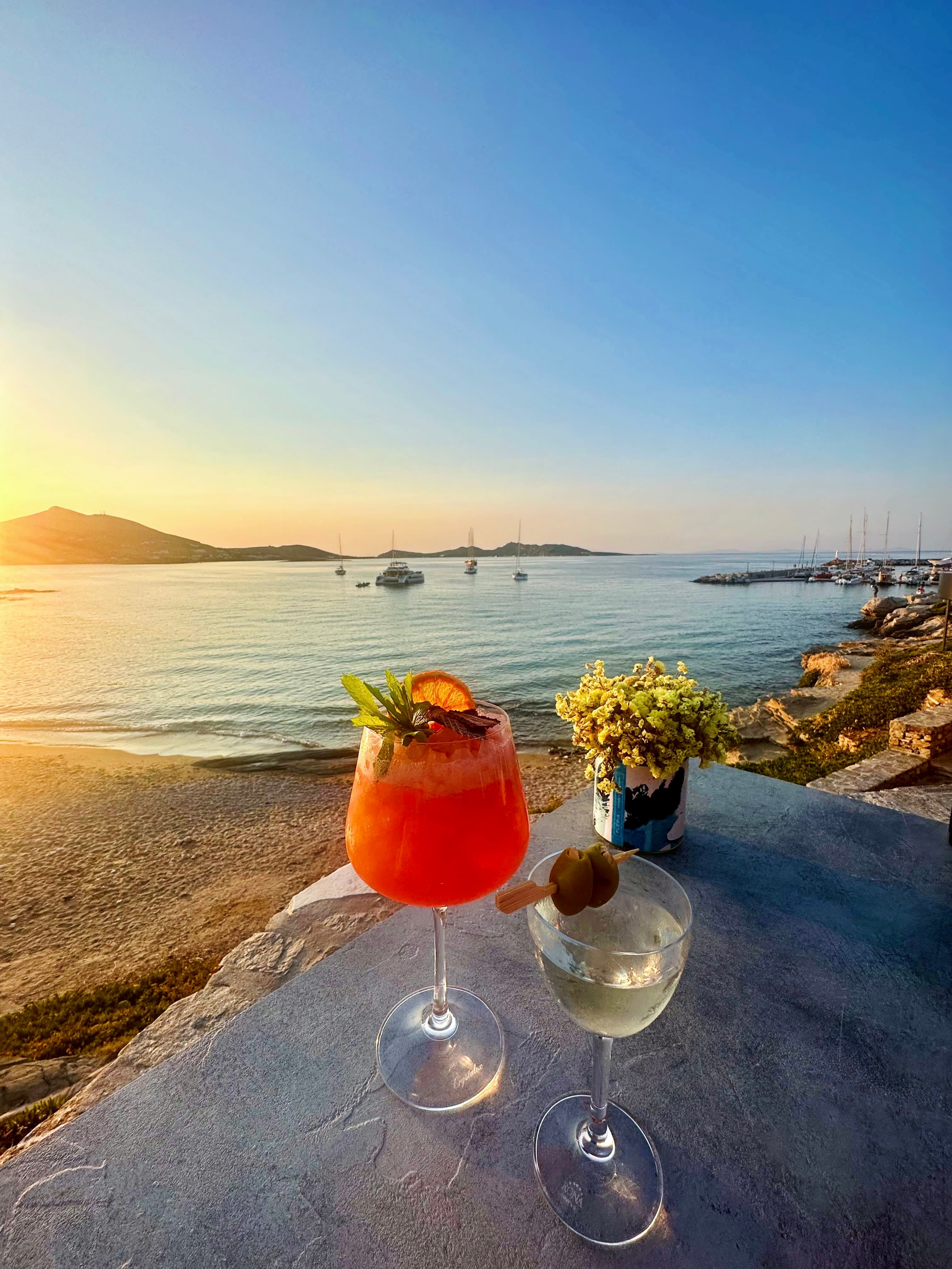 Colorful cocktails on a stone table on the beach at sunset