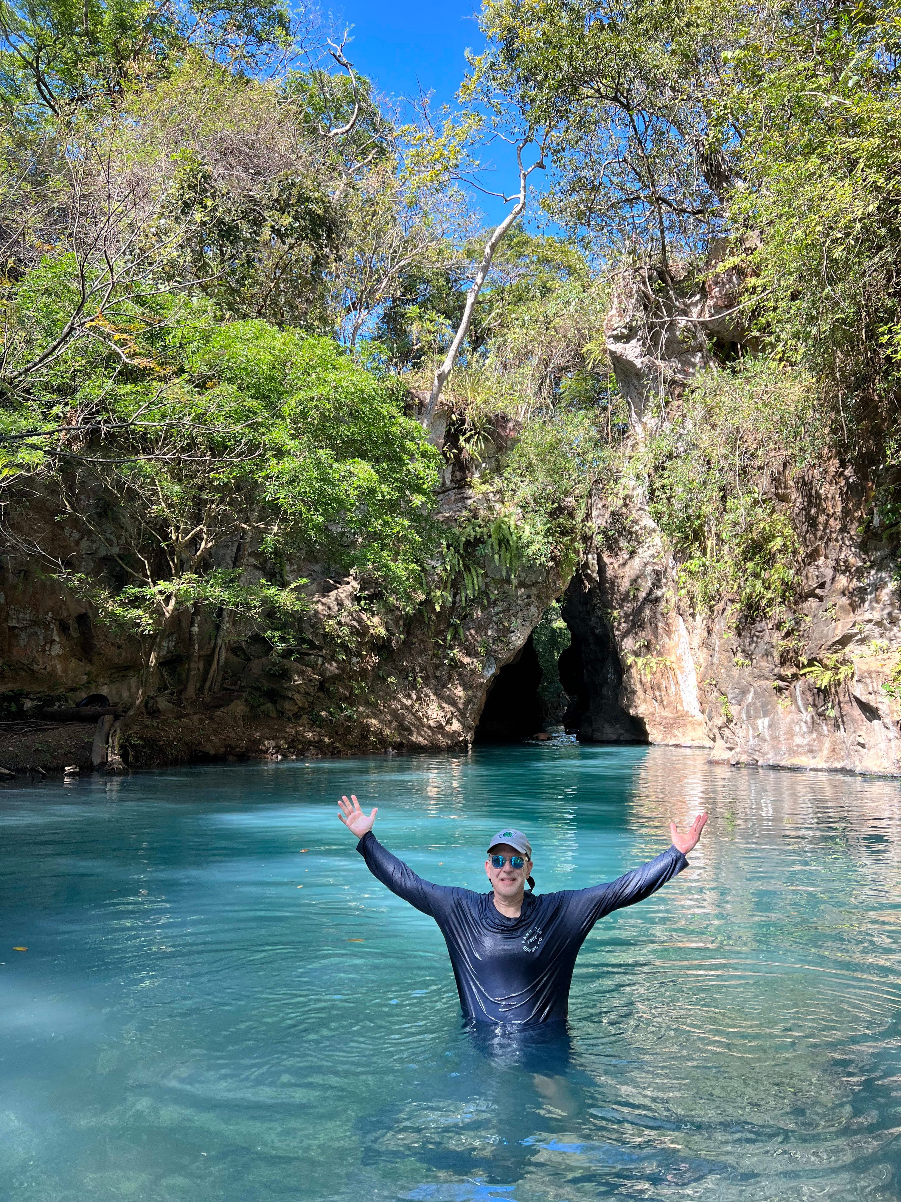 Picture of Jayson swimming in a watering hole with foliage in the background